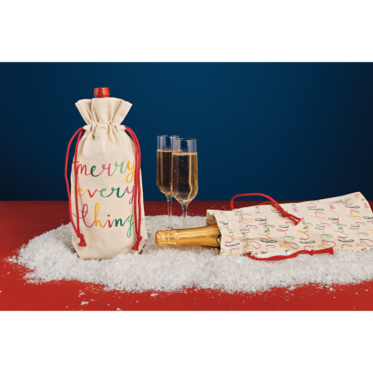 A Christmas Danica Jubilee wine bag with a bottle of wine and a bottle of champagne next to champagne glasses.