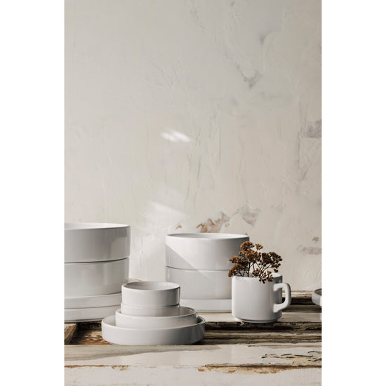 A set of Heirloom Ivory Foundation dinnerware including plates, bowls, and cups on a table.