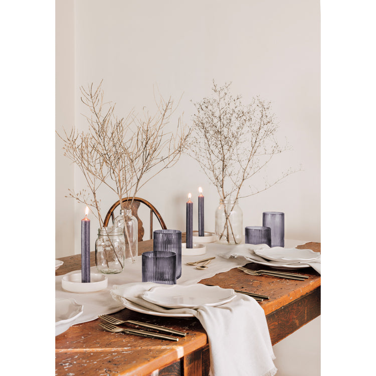 A wooden table with Heirloom Provence dinnerware and Smoke gray Fluted glassware.