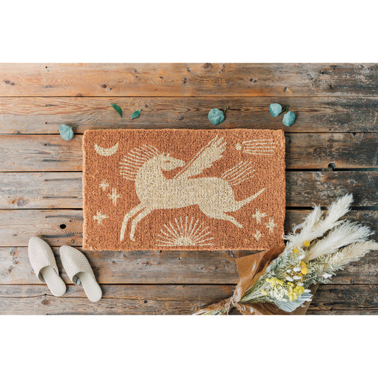 A Danica Studio doormat with an image of a pegasus horse on it.