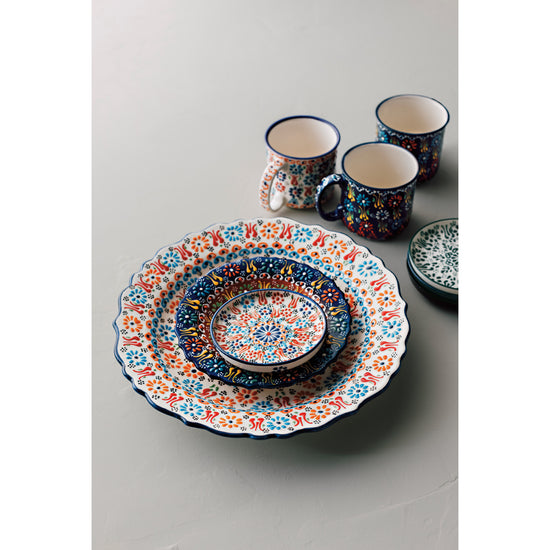 A set of Heirloom Evani plates, dishes, and mugs on a table.