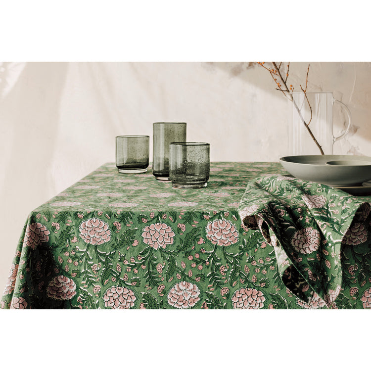 A floral Heirloom Peony Block Print Tablecloth and Napkins and Agave green Bubbled Tumbler glasses.